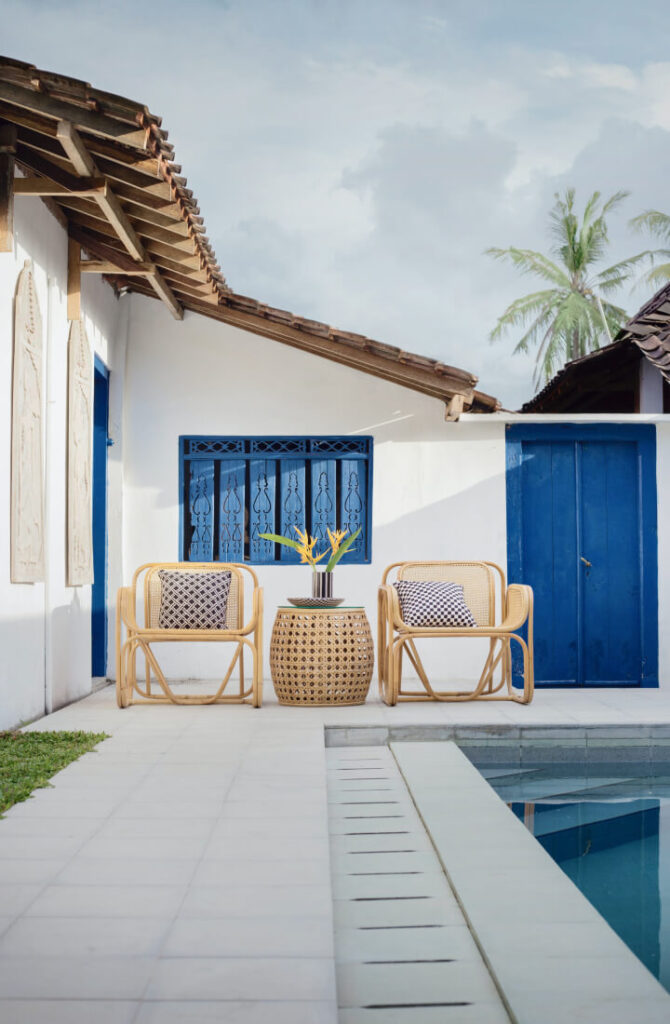 Zwei Stühle stehe vor einem Haus am Pool.